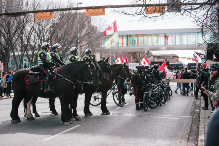 Mounted police unit in Calgary City Hall Canadian flags waving in the background